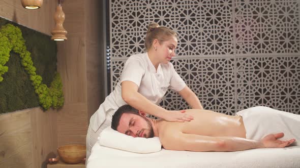 Woman's Hands Doing Massage To Handsome Unshaven Man