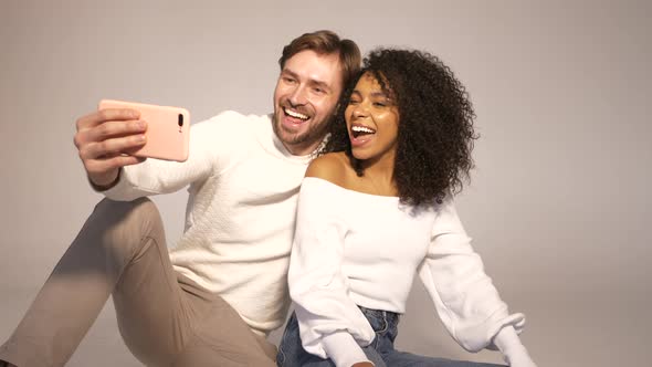 Smiling beautiful woman and her handsome boyfriend posing in studio