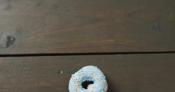 Video of donut with icing on wooden background