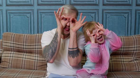 Father and Child Daughter Kid in Pajamas Fooling Sit on Couch in Living Room Smile Look at Camera