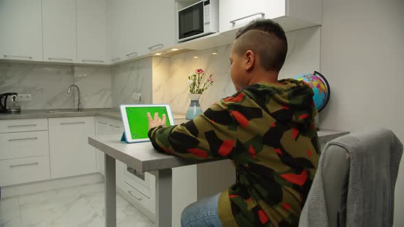 School Kid Studying Online Using Digital Tablet with Chroma Key Indoor