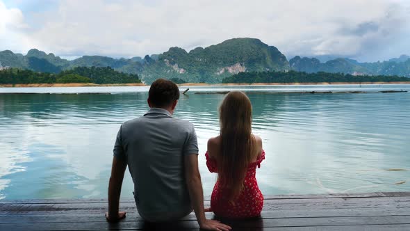 Man Move Away From Woman on Date on Lake and Beautiful Mountains Landscape