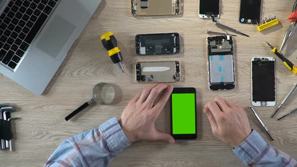 Repairer Checking Phone Functionality After Fixing, Smartphone With Green Screen