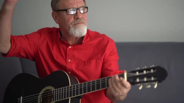 Portrait of a Mature Man with Glasses and a Guitar