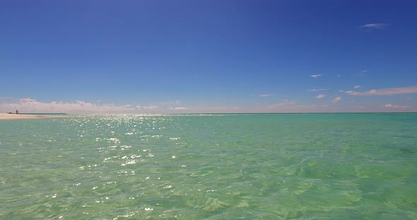 Beautiful drone abstract shot of a white sand paradise beach and blue sea background in vibrant 4K