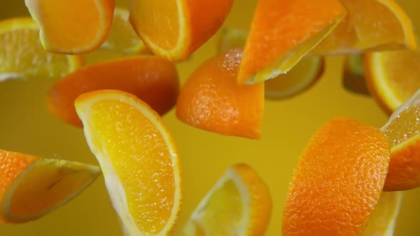 Juicy Slices of Orange Are Bouncing on the Yellow Background