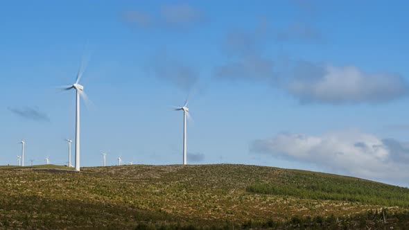 Time lapse of wind turbines in remote landscape area during daytime with passing clouds in Ireland. alt