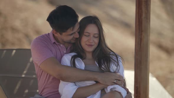 Happy Lovers on Beach Man is Hugging Young Beautiful Woman Happy Summer Weekend