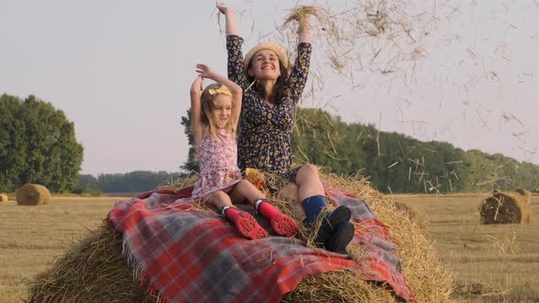 Woman with Little Daughter Having Fun on Hay Bale