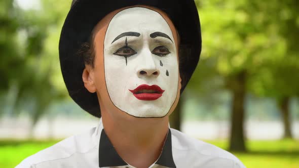 Mime in a Black Hat Smokes Outdoors. Bad Habits