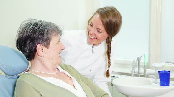 Happy female dentist with patient looking at camera