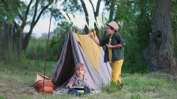 Outdoor Children Cute Boys Enjoy Spending Time Together and Building Tepees on the Lawn Among the