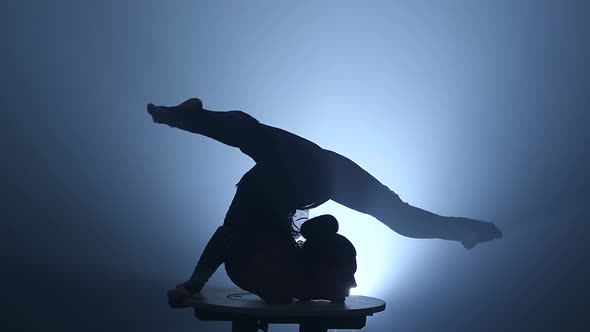 Gymnast Artist Performing on the Stage. Smoke Background. Slow Motion. Silhouette