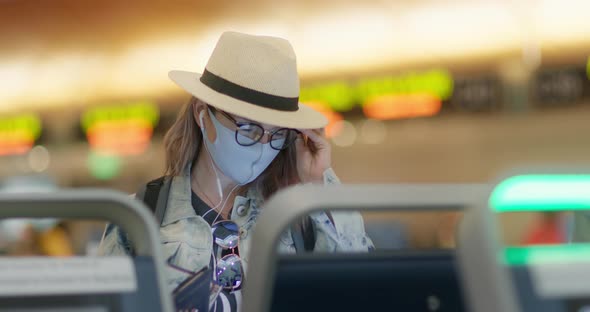 Young Woman in Reading Glasses and Face Mask Checkingin To Flight in Airport