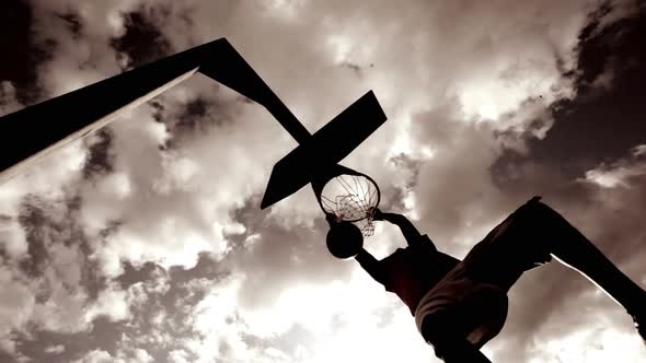 Basketball player dunking basketball and scores in basket