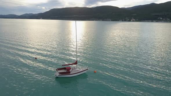 Aerial View of a Small Yacht on a Big Lake in Mountains