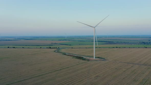 Aerial View of a Windmill in Agricultural Fields Generating Renewable Energy