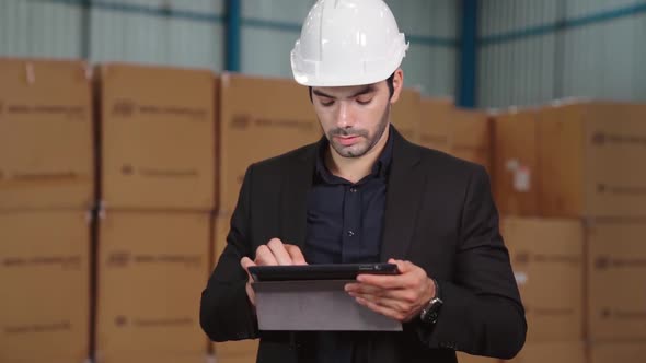 Factory Manager Using Tablet Computer in Warehouse or Factory