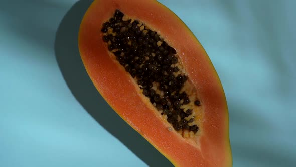 Tropical Fruit Papaya on a Colored Sunny Background with Shadows of a Palm Tree