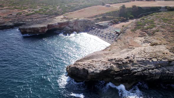 Drone footage of the wild Cretan beach, blue logon between rocky hills, coral reefs.