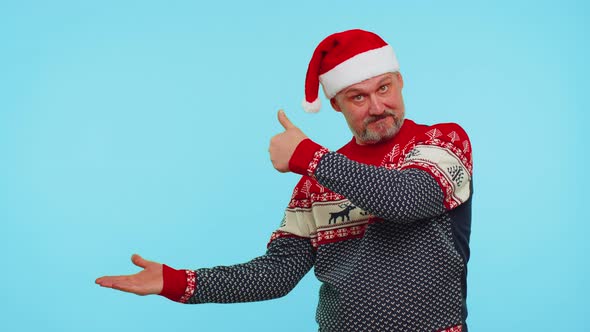 Man in Red Sweater Santa Christmas Showing Thumbs Up and Pointing Empty Place Advertising Area