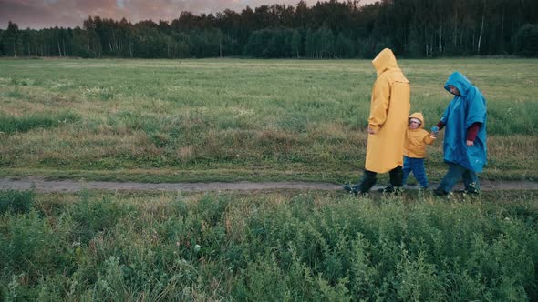 Family with Child are Walking in Park in Evening