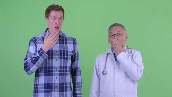 Mature Japanese Man Doctor with Young Man Looking Shocked Together