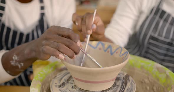 Black Couple Decorating Plate in Workshop During Class