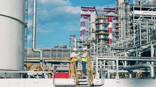 Premises of the Oil Refinery with Industrial Workers Talking