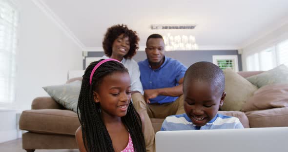 Children using laptop in living room