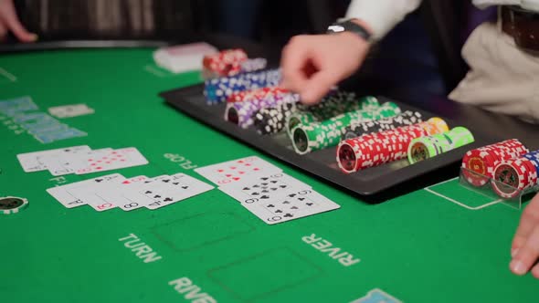 People play casino in the club. Gambling table with players hands in dark indoors