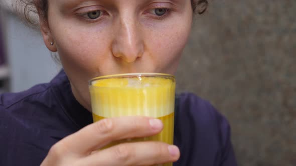 Close Up of Female Drinking Vegan Turmeric Coffee Latte