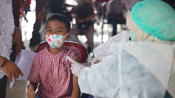 Yogyakarta, Indonesia - Des 20, 2021 : an elementary school boy is receiving the covid-19 vaccine