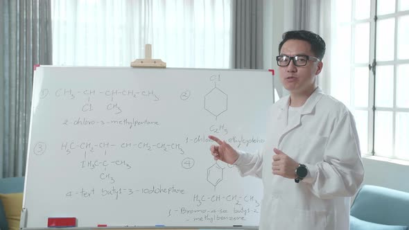 Asian Male Teacher With Glasses Teaching Chemist At Home