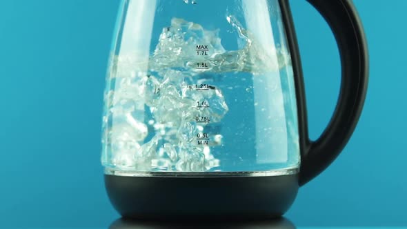 An Electric Kettle with Glass Walls. Process of Boiling. Blue Background. Concept