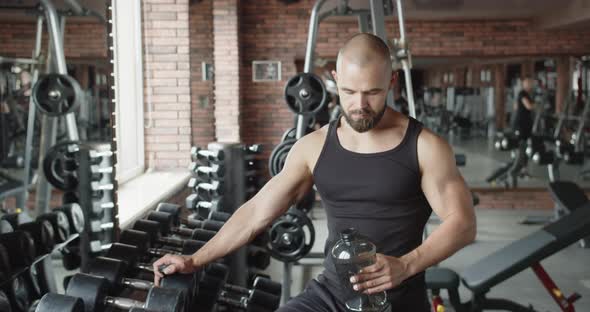 Tired Athlete Drinks Water During Training