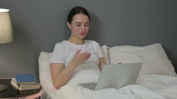 Video Chat on Laptop By Young Woman in Bed
