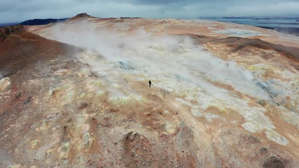 Man Walks On Red Mountains in The Hverir Geothermal Area Near Lake Myvatn