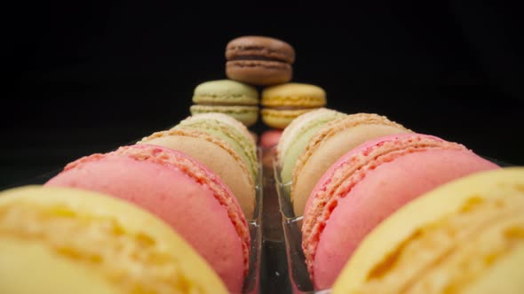 Colored Macaroons Confectionery Marshmallows on a Black Reflective Background in Perspective