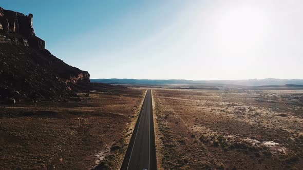 Cinematic Aerial Drone Shot of Breathtaking Desert Wilderness with Massive Rocky Mountain and Cars