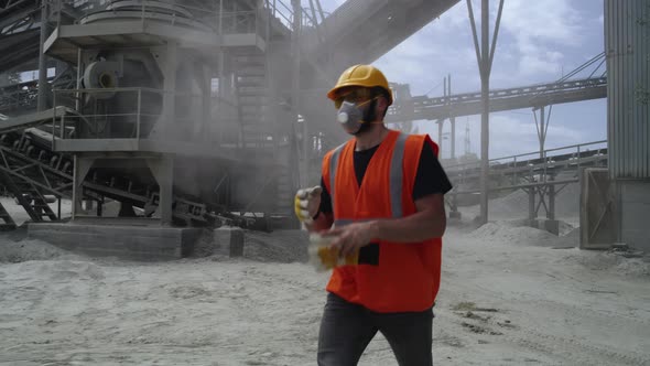 Male Quarry Worker Removing Protective Gear alt
