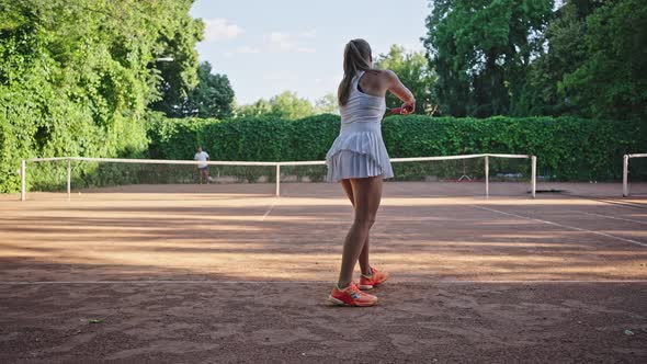 Female Tennis Player Hits Ball to Opponent on Court Closeup