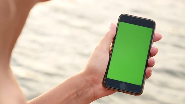 NICE, FRANCE - JULY 2017 Woman with chroma key gadget in hands by the  beach