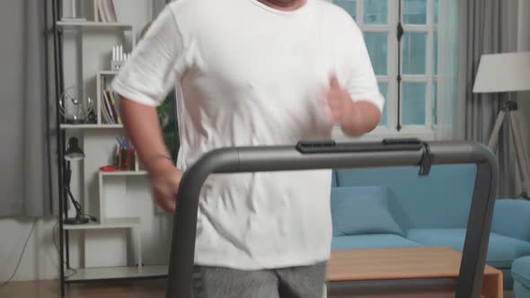 Asian Fat Man Running On A Treadmill At Home At Home