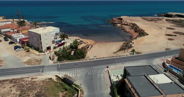 Drone Flaying Above the Street Ups Camera Approaching to the Beach and Blue Sea