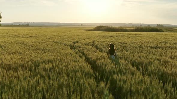 Girl Walking in Field at Sunset Flying Around