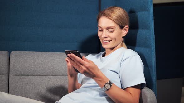 Focused Business Woman Typing Message on Mobile Phone at Coworking Center