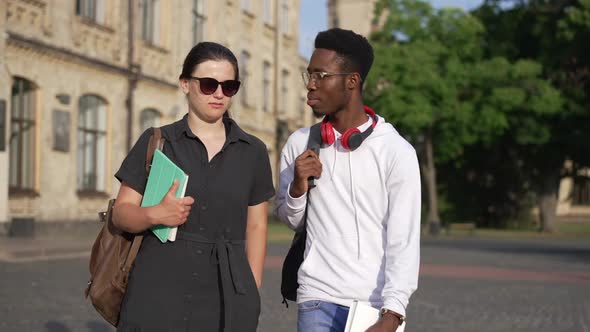 Dolly Shot Confident African American Man and Caucasian Woman Walking Outdoors Talking at University