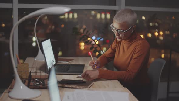 Business Lady Working Overtime in Dark Office