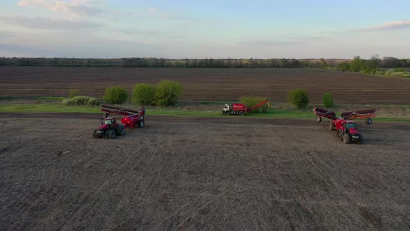 Drone Footage of the Field with Tractors and Trucks Planting Seeds